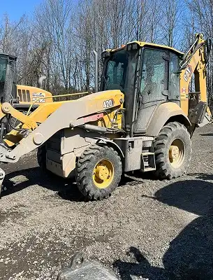 dirty mini excavator with dirt, grease and grass smeared on