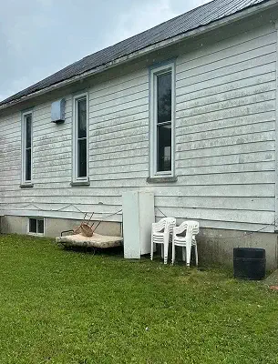 house siding with mold, dirt and grass