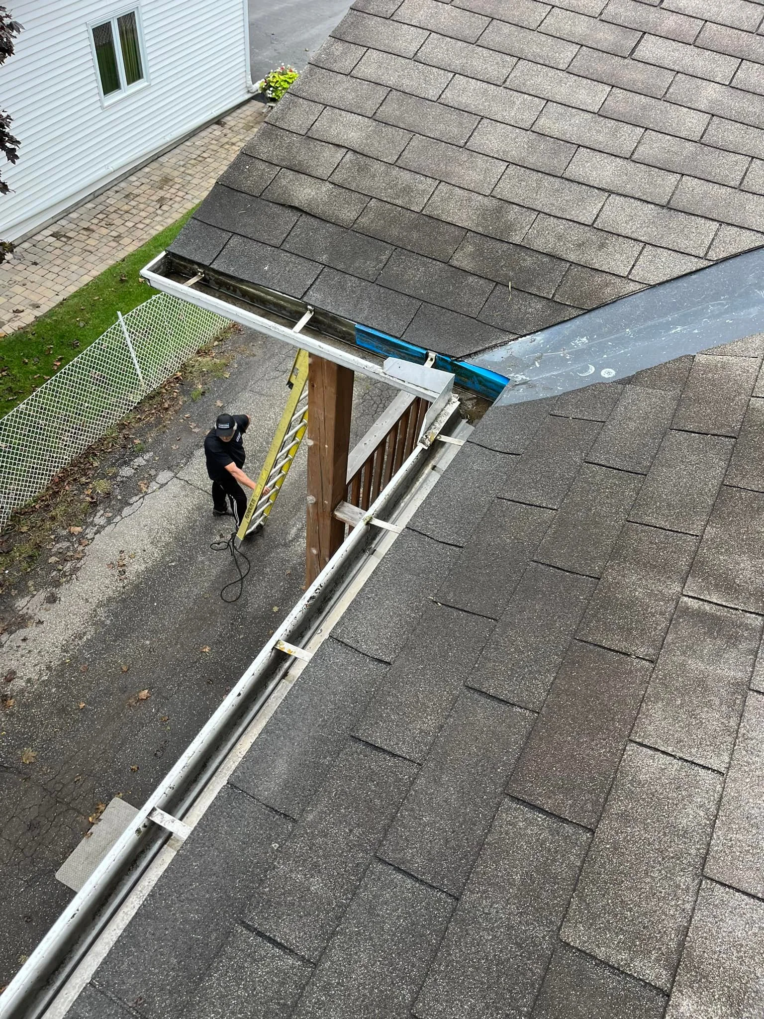 A man climbing a ladder while preassure washing