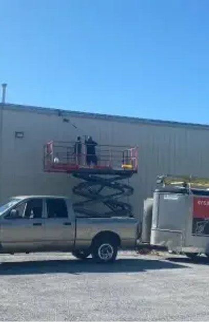 a man preassure washing a dirty industerial warehouse