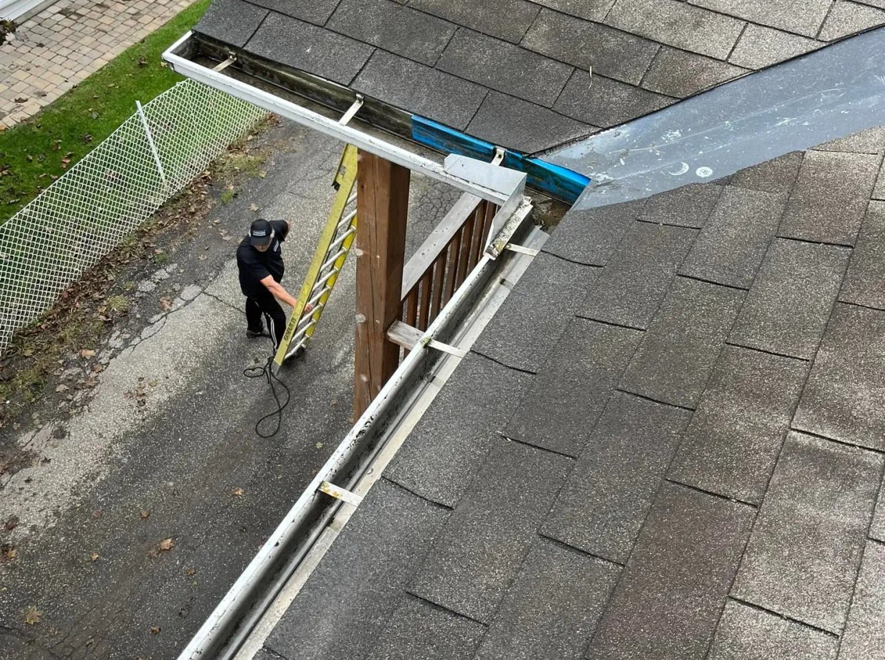 A man climbing a ladder while preassure washing