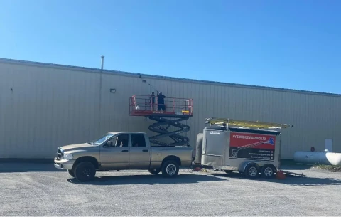 a man preassure washing a dirty industerial warehouse